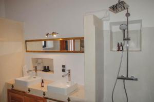 un baño con dos lavabos y una ducha en AdaZen Ecolodge, en Azilal