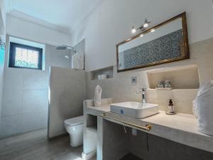 Un baño con lavabo, inodoro y espejo. en AdaZen Ecolodge, en Azilal