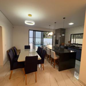 a kitchen and dining room with a table and chairs at Recanto dos Sonhos Ninho Verde 2 in Pardinho +23 photos