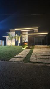 a building with a lit up front of it at night at Recanto dos Sonhos Ninho Verde 2 in Pardinho