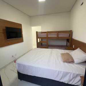 a bedroom with a bed and a flat screen tv at Recanto dos Sonhos Ninho Verde 2 in Pardinho