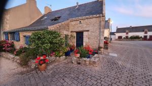 a stone building with flowers in pots on a street at QUIBERON Maison Le Manémeur Port Maria in Quiberon