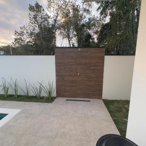 a wooden garage door on a white wall at Recanto dos Sonhos Ninho Verde 2 in Pardinho