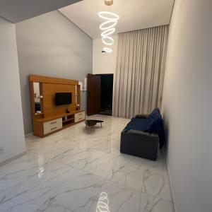 a living room with a couch and a television at Recanto dos Sonhos Ninho Verde 2 in Pardinho