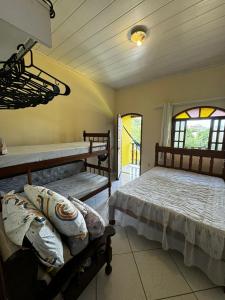 a bedroom with two beds and two windows at Espaço Carvalhaes in Cabo Frio