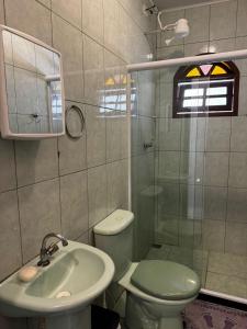 a bathroom with a toilet and a sink and a shower at Espaço Carvalhaes in Cabo Frio