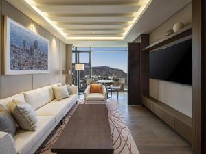 a living room with a couch and a flat screen tv at The Ambassador Seoul - A Pullman Hotel in Seoul