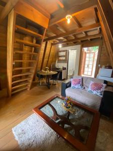 a living room with a couch and a table at Chalé com jacuzzi Florianópolis in Florianópolis +14 photos