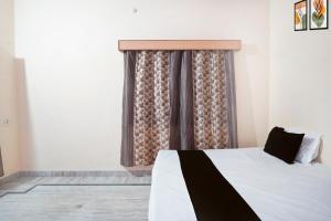a bedroom with a bed and a window at SPOT ON Muskan Lodge & Restaurants in Jāmul