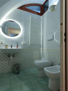 a bathroom with a sink and a toilet and a mirror at Residence Stella in Pomigliano dʼArco