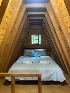 a bed with two towels on it in an attic at Chalé com jacuzzi Florianópolis in Florianópolis