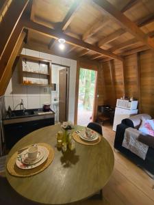 a kitchen and a table in a living room at Chalé com jacuzzi Florianópolis in Florianópolis