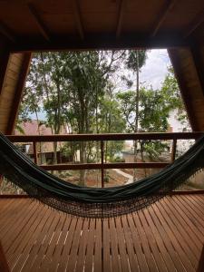 a hammock in a room with a large window at Chalé com jacuzzi Florianópolis in Florianópolis