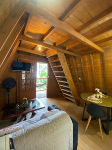 a living room with a couch and a spiral staircase at Chalé com jacuzzi Florianópolis in Florianópolis