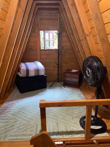 a attic room with a fan in the attic at Chalé com jacuzzi Florianópolis in Florianópolis