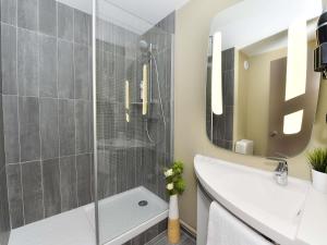 a bathroom with a shower and a white sink at ibis Beaune La Ferme Aux Vins in Beaune +89 photos