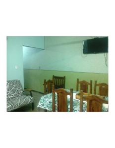 a room with a table and chairs and a television at Hostel Jandira in Rio de Janeiro