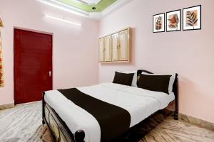 a bedroom with a large bed with a red door at Hotel O Buckingham Canal Vijayawada in Mutyālammapādu