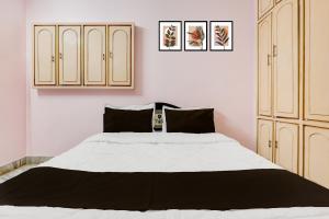 a bedroom with a large white bed and cabinets at Hotel O Buckingham Canal Vijayawada in Mutyālammapādu