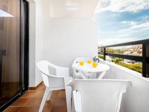 Una mesa blanca y sillas en un balcón con vista. en Charming apartment with an excellent location, en Arona