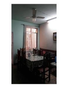una sala da pranzo con tavolo, sedie e ventilatore a soffitto di Hostel Jandira a Rio de Janeiro