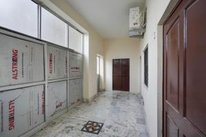 Un pasillo vacío con una puerta y una habitación con un mapa en SPOT ON Ksg Bakery, en Mandor