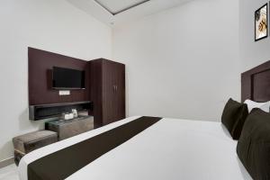 a bedroom with a large bed and a tv at Hotel O Shree Guru Kanha Vaishno Dham in Chhatikara