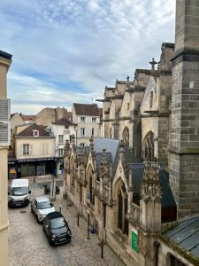 an old building with cars parked in a parking lot at Le Perché in Melun