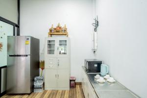 Ao Nang Boutique Apartment & Pool في شاطيء آونانغ: مطبخ مع ثلاجة وكاونتر مع أكواب