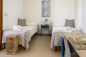 una habitación con dos camas y una mesa azul en Attico La Fenice, en Àrbatax