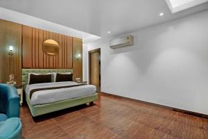 a bedroom with a bed and a blue couch at Hotel O elvilla in New Delhi +21 photos