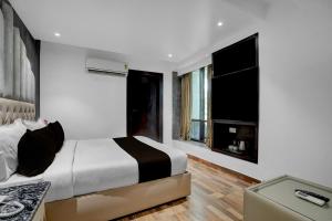 a bedroom with a bed and two windows at Hotel O elvilla in New Delhi