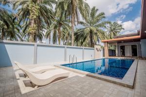 Ao Nang Boutique Apartment & Pool في شاطيء آونانغ: مسبح في حديقه خلفيه مع منزل