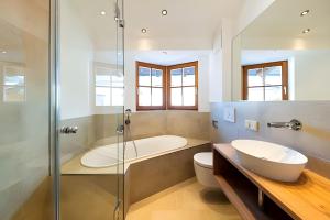 a bathroom with a tub and a toilet and a sink at Chalet Steinberg in Leogang +15 photos