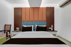 a bedroom with a large bed and two chairs at Hotel O elvilla in New Delhi