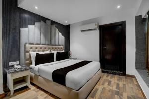 a bedroom with a large bed with a black and white blanket at Hotel O elvilla in New Delhi