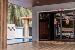 Ao Nang Boutique Apartment & Pool في شاطيء آونانغ: منزل به باب زجاجي وسيارة بالخارج