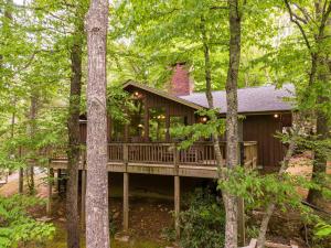 a cabin in the woods with a wrap around deck at Bucky's Hideaway in Todd