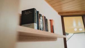 a row of books sitting on a book shelf at Ferienwohnungen Bullau in Erbach