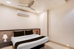 a bedroom with a bed and a ceiling fan at Hotel O Vatva Railway Station Formerly Anmol Palace in Ahmedabad