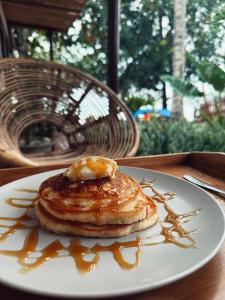 une assiette de crêpes avec du sirop sur une table dans l'établissement BAIA - Beachfront Boutique Lodge in San Vicente, Palawan, à San Vicente