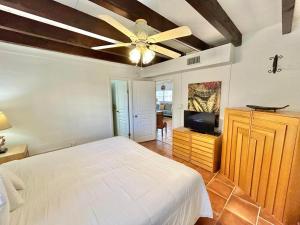a bedroom with a white bed and a ceiling fan at Baked and Barefoot Beach Bunglows in St. George Island