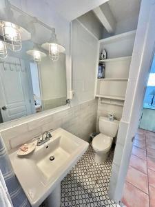 a white bathroom with a sink and a toilet at Baked and Barefoot Beach Bunglows in St. George Island +23 photos