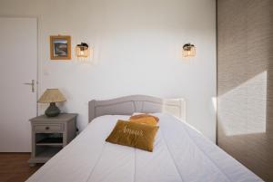 a bedroom with a bed with a pillow on it at Gîte l'orée de la forêt légendaire in Néant-sur-Yvel