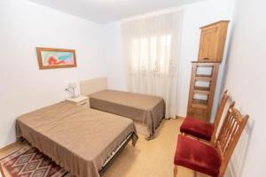 a small room with two beds and a chair at Apartment Mountain View in Torrox