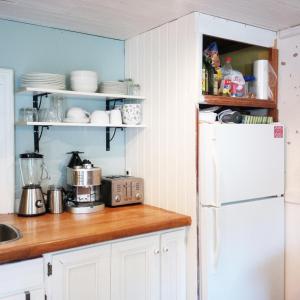 a kitchen with white cabinets and a white refrigerator at Picturesque School House Retreat in Meaford