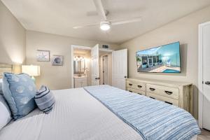 a bedroom with a large bed and a flat screen tv at Honeysuckle - L in Siesta Key +67 photos