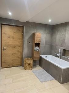 a bathroom with a large tub and a wooden door at Thaya-Auszeit in Thaya +18 photos