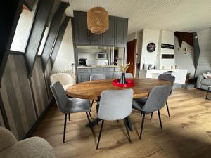 a kitchen and dining room with a wooden table and chairs at Le Delta de Super-Besse in Super Besse