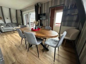 a living room with a wooden table and chairs at Le Delta de Super-Besse in Super Besse +6 photos